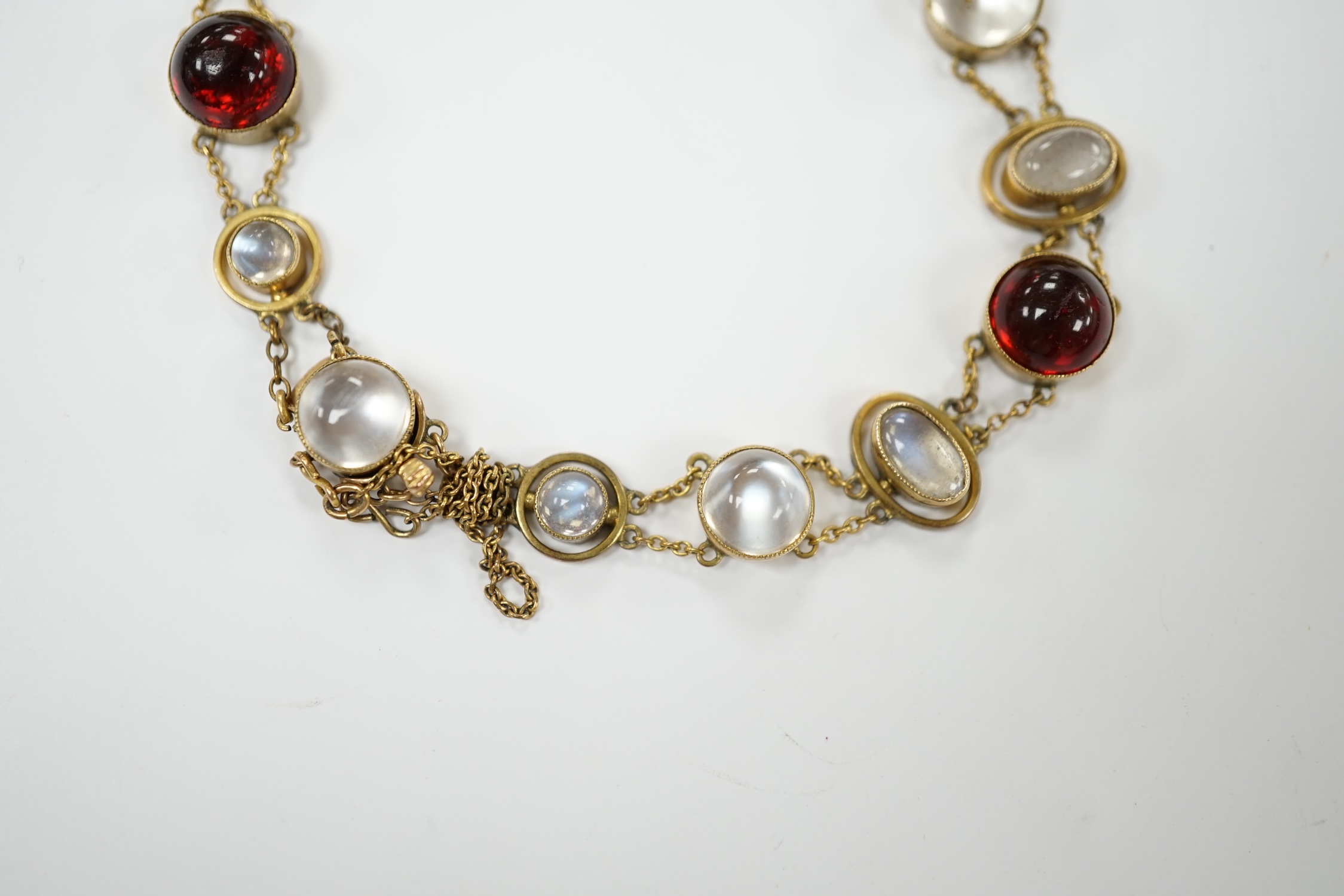 A George V 9ct, cabochon moonstone and cabochon red paste set bracelet, 16.5cm, gross weight 12 grams, Condition - fair